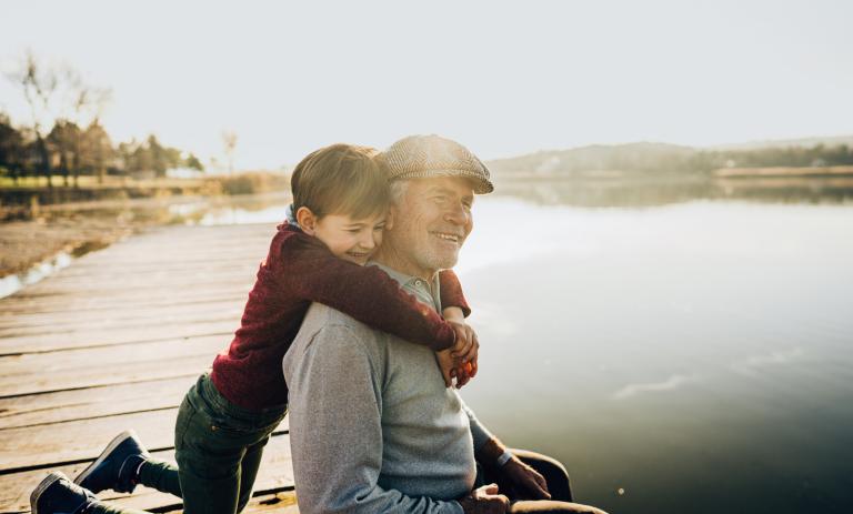 grandfather and grandson on a lake dock