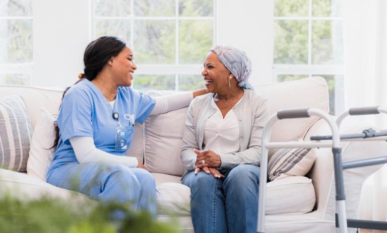 A nurse chats with a client in their home