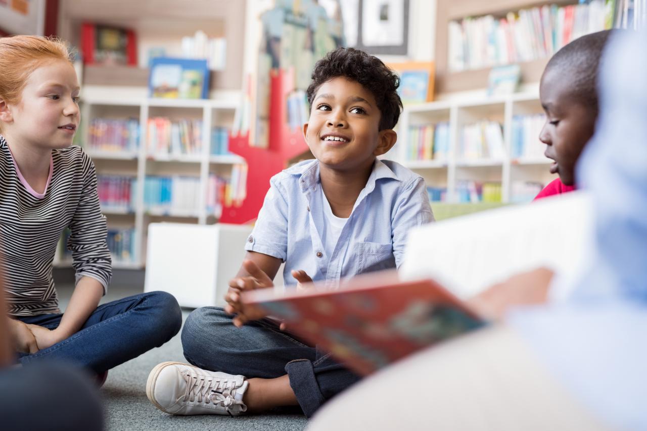 A group of children reading books in a library