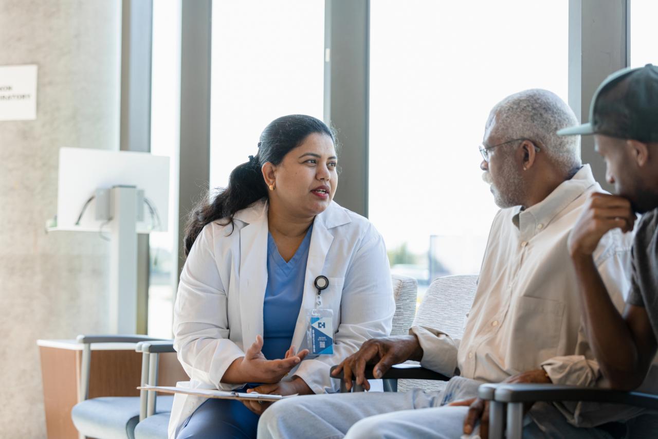 a doctor discusses medical issues with her senior adult as the support person listens in.