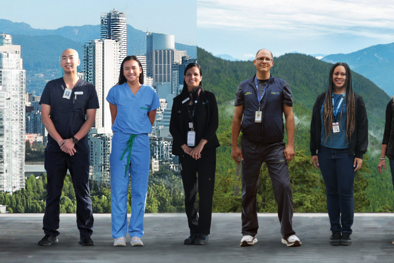 Staff standing against backdrop of city and mountains