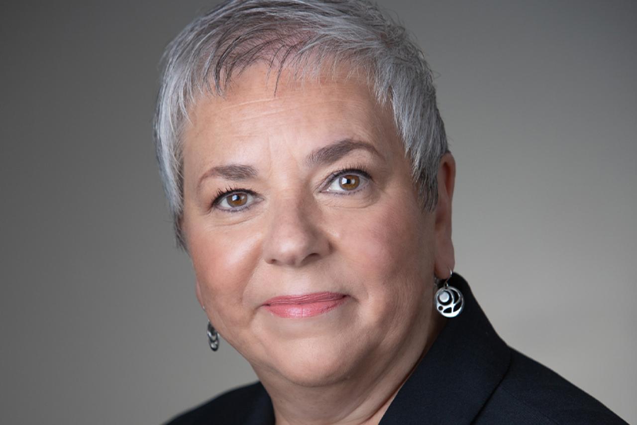 A portrait of Vivian Eliopoulos in front of a grey background