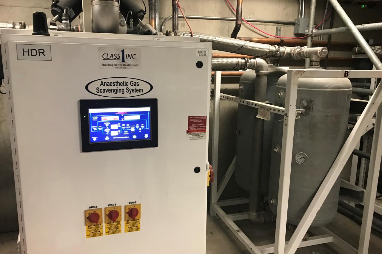 A rectangular white gas scavenging machine in a mechanical room