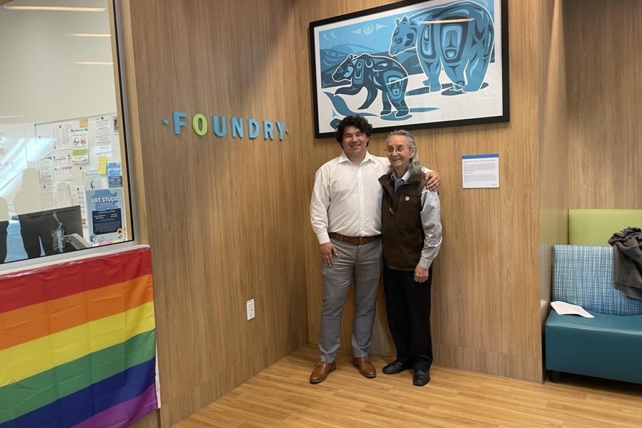 Indigenous artist and Elder standing in front of new artwork at Foundry Richmond. 