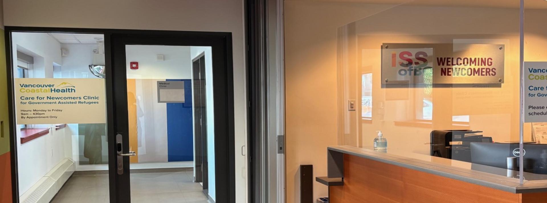Reception area of a medical clinic with white walls and wood paneling on a large counter