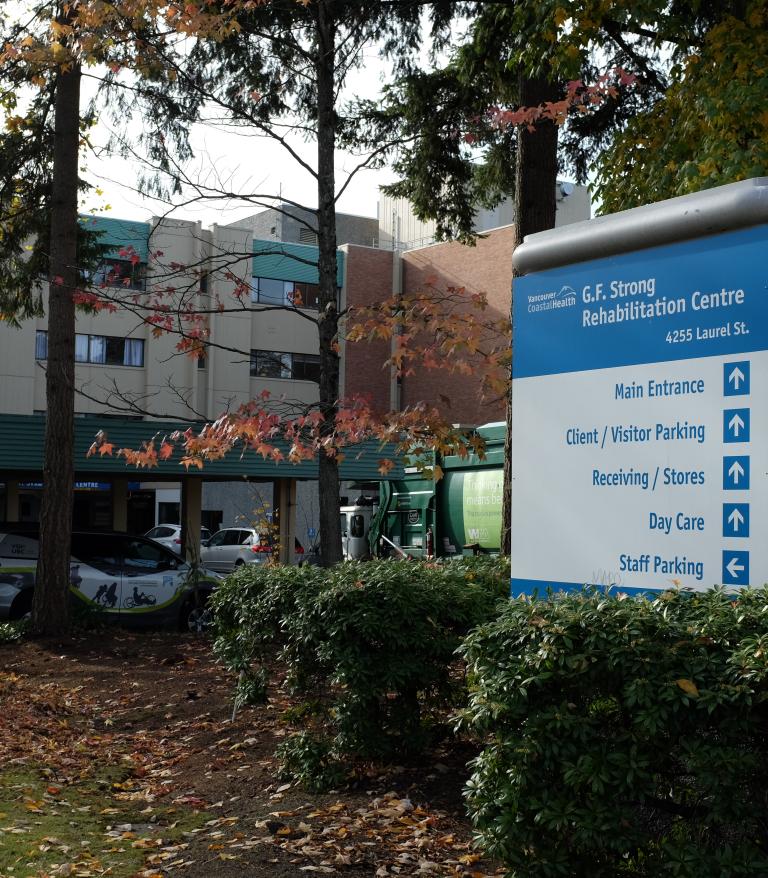 Exterior of G.F. Strong Rehabilitation Centre with wayfinding sign in the foreground