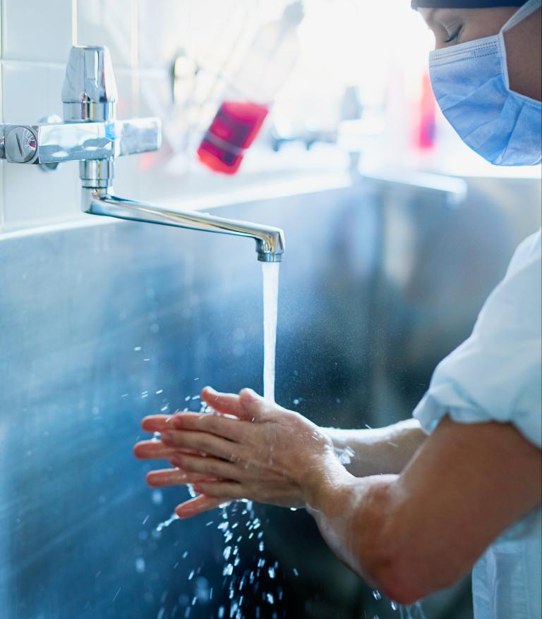 A young surgeon washing their hands to prepare for surgery