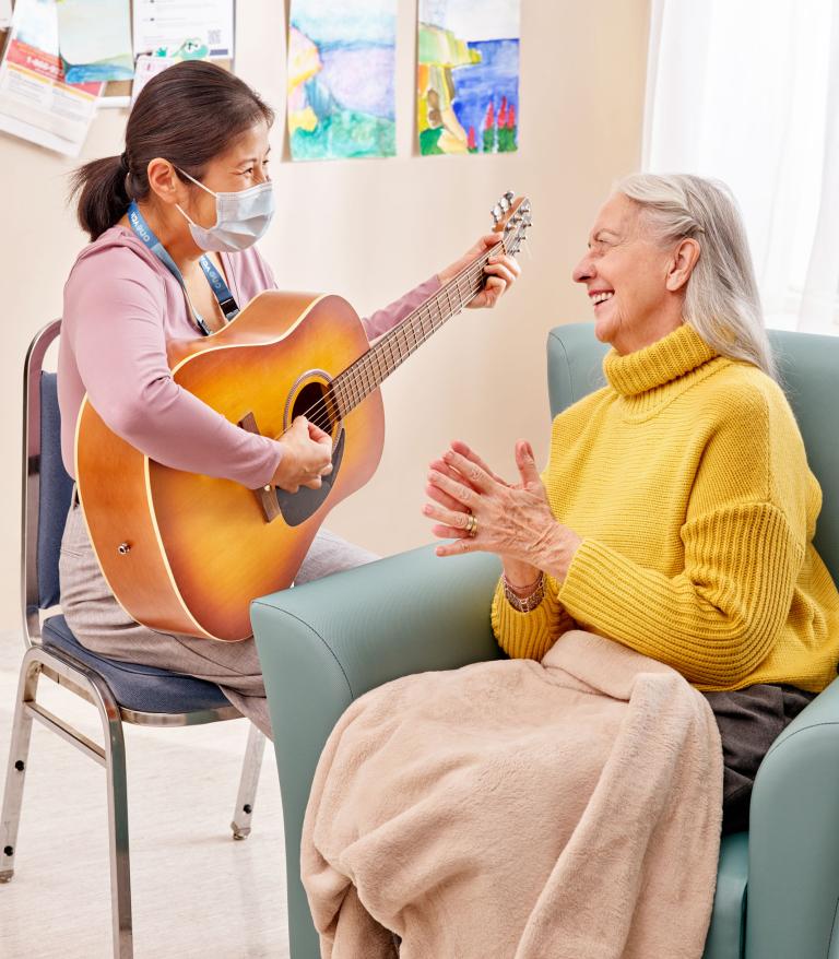 music therapist plays guitar for a patient 
