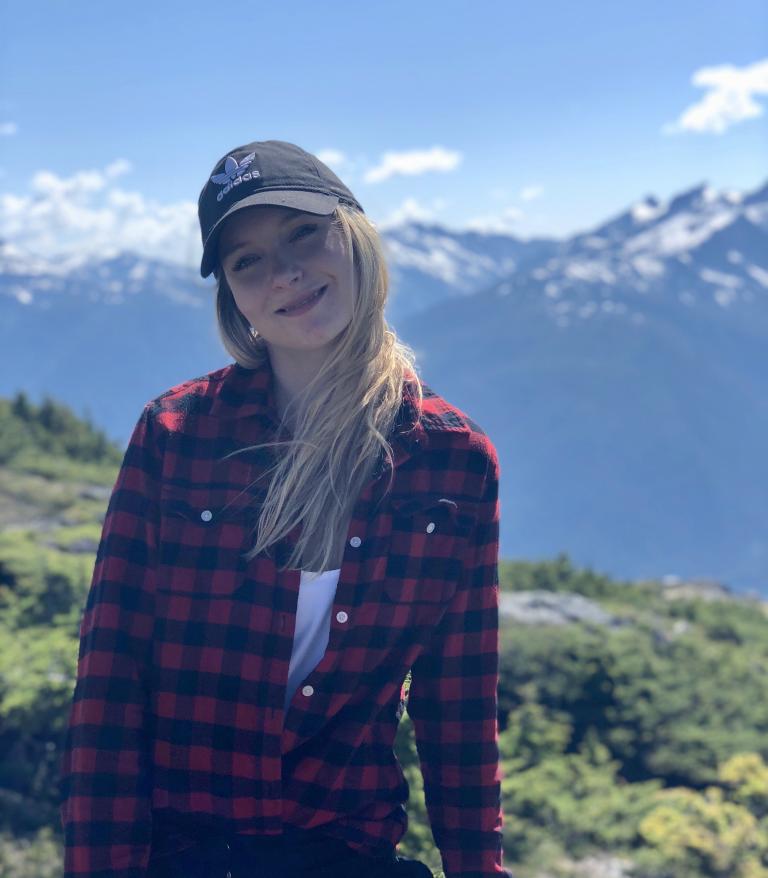 Jenna Gagnon, CLXT, standing with mountains in the background.