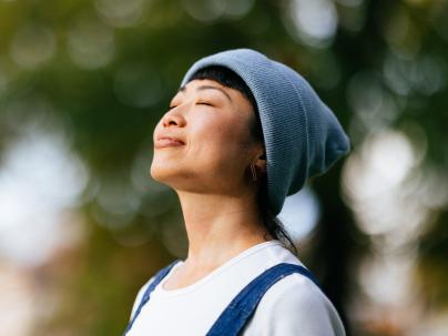 A person taking a deep breath while outside on a sunny day