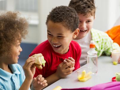 Group of children having packed lunches