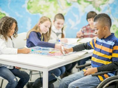 five children working on schoolwork in a classroom