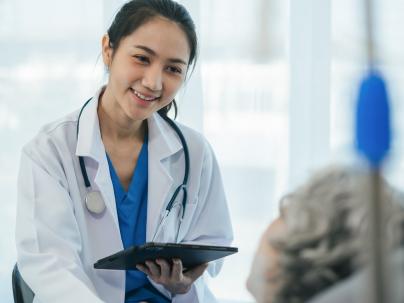Doctor giving patient information while they lay in a hospital bed