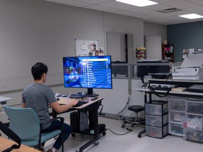 Person sitting at computer using technology in the G.F. Strong Assistive Technologies Lab