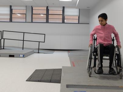 Person in wheelchair using the wheelchair skills room.