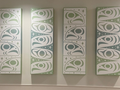 4 Indigenous artworks in a row mounted on a wall 