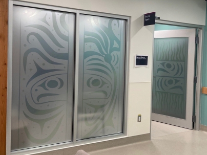 Indigenous artwork mural on top of windows and a door