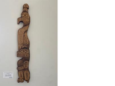 Indigenous wooden carving mounted on a white wall 