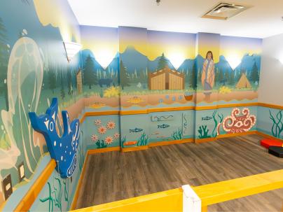 Indigenous mural of a forest and sea on a wall with interactive animals 