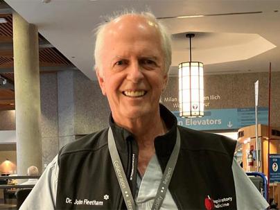 Headshot of a man wearing medical scrubs and a vest