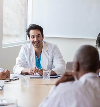 Closeup of a dropper of blue liquid above a row of test tubes