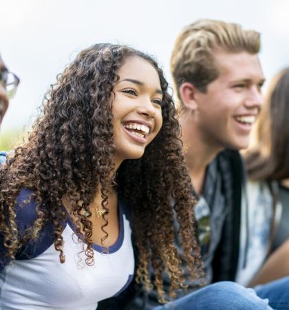 Four youth smiling for a picture outside.